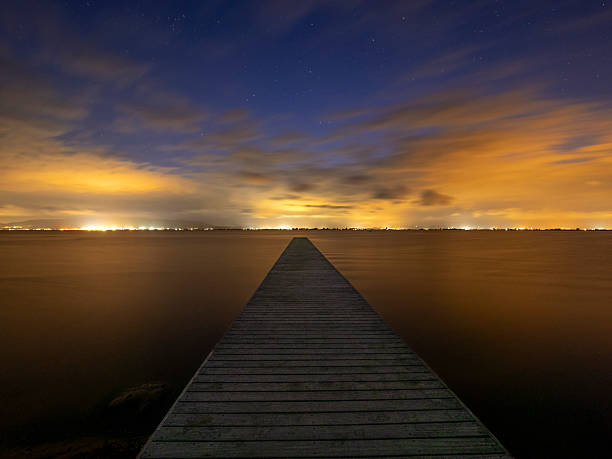istock Illuminated pier over the sea at night 2233110606