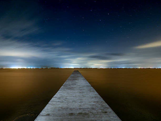 istock Illuminated pier over the sea at night 2233110615