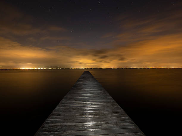 istock Illuminated pier over the sea at night 2233110619