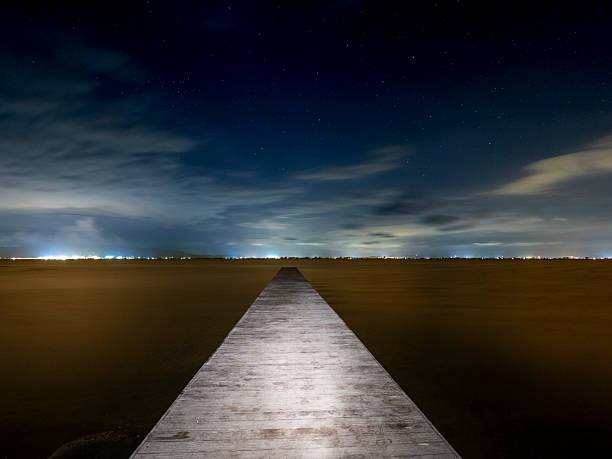 istock Illuminated pier over the sea at night 2233110632