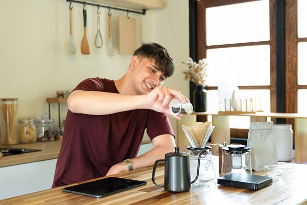 istock Man brewing manual coffee in minimalist kitchen with morning light 2233114264