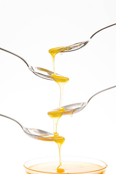 istock Honey drips from spoon to spoon in creative stacking arrangement indoors 2233114963