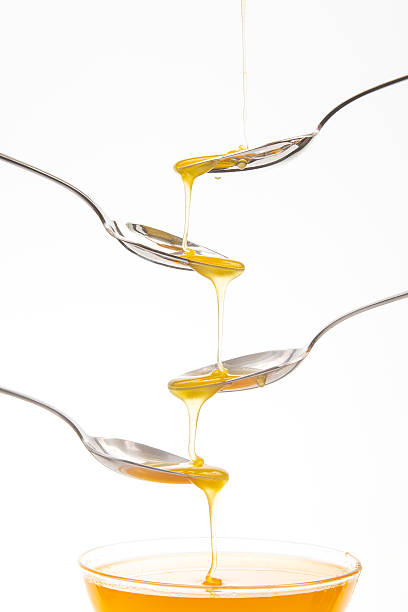 istock Honey drizzles from one spoon to another in a creative kitchen activity 2233117122