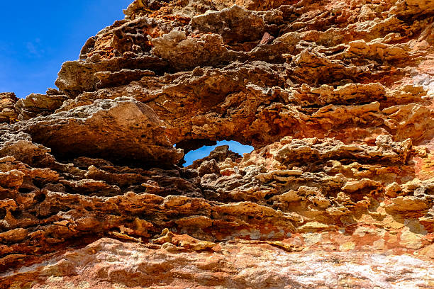 Dramatic coastal rock formations at Gantheaume Point, Broome, Western Australia, with striking red cliffs contrasting against turquoise waters of the Indian Ocean. A scenic natural landmark known for its rugged beauty and dinosaur footprints