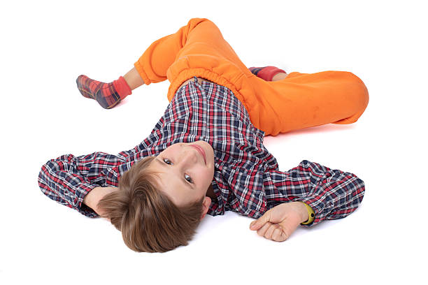 Teenage boy smiling and lying head down on white background