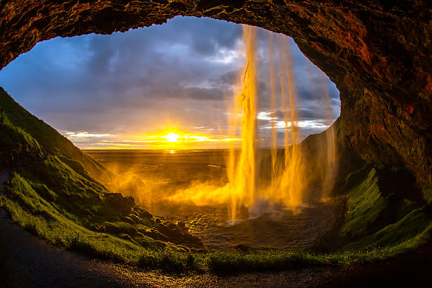 istock Waterfall cascade at sunset viewed through cave in Iceland 2233118709