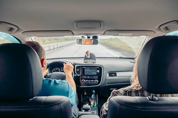 istock driver holding steering wheel inside modern car while passenger sits in front seat, road trip, interior dashboard, navigation screen, rearview mirror reflection, travel, transport 2233119487