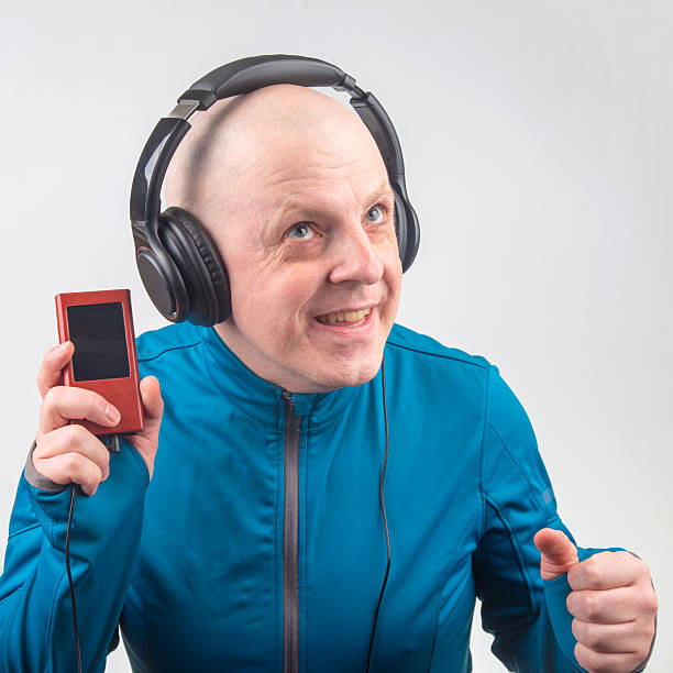 Modern small black MP3 music player with empty screen on vinyl records with earbuds.
