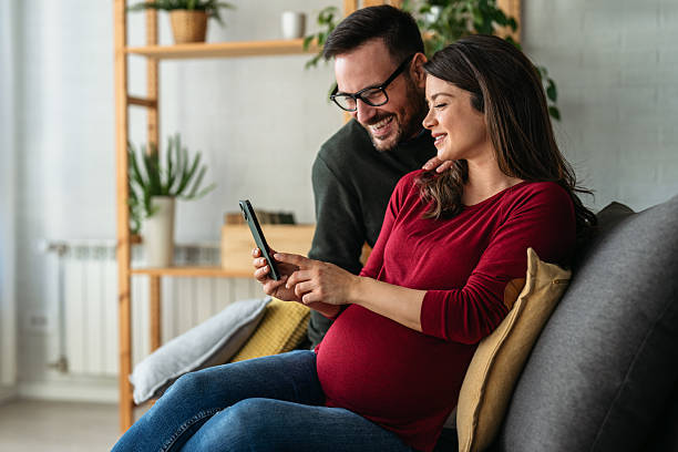 istock Happy young pregnant couple using virtual mobile service, online app on smart phone, 2233121868