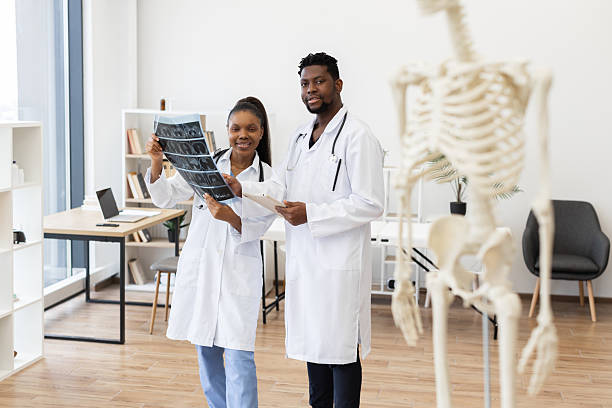 istock Doctors reviewing X-rays in clinic with skeleton model in foreground 2233123862