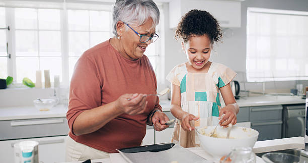 istock Baking, happy and grandma with child in kitchen for learning, teaching and helping for cookies. Family, home and grandmother with girl with flour, ingredients and bonding for dessert, cake and pastry 2233125516