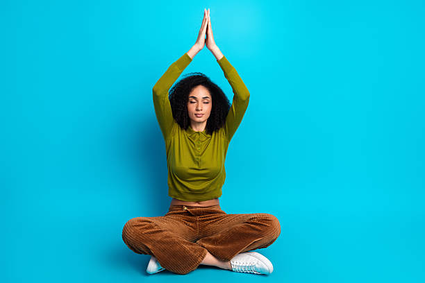 istock Serene young woman meditating in casual attire against a vibrant blue backdrop, practicing mindfulness 2233127901