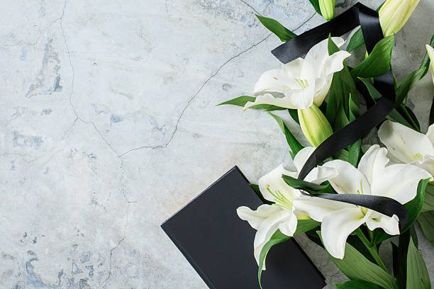 istock Elegant white lily bouquet with black ribbon on stone surface, symbolizing mourning, remembrance, and sympathy. 2233130925