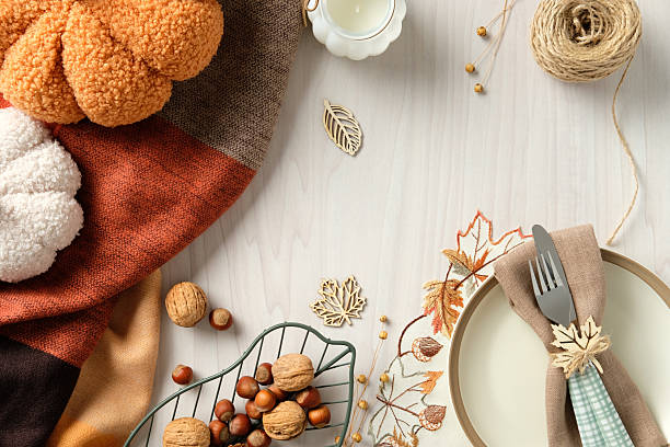 istock Elegant autumn table setting with plush pumpkins, rustic napkin decor, nuts, and warm-toned fabric. Perfect for Thanksgiving, harvest celebration 2233131397