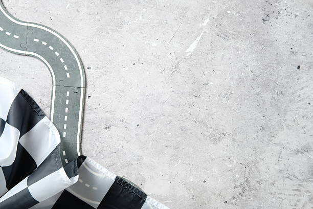 istock Curved toy road and checkered flag on textured concrete 2233131617