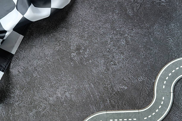 istock Winding miniature road with checkered finish flag on textured asphalt 2233132308