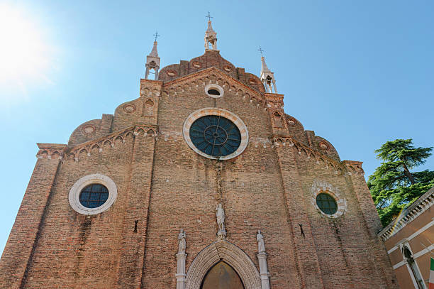 istock Historic Venetian church showcasing Gothic architecture with circular windows and stone sculptures on red brick faÃ§ade 2233133065