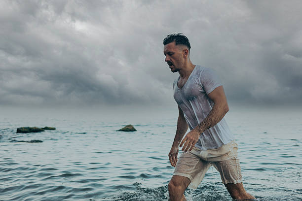 A handsome man is walking near the sea