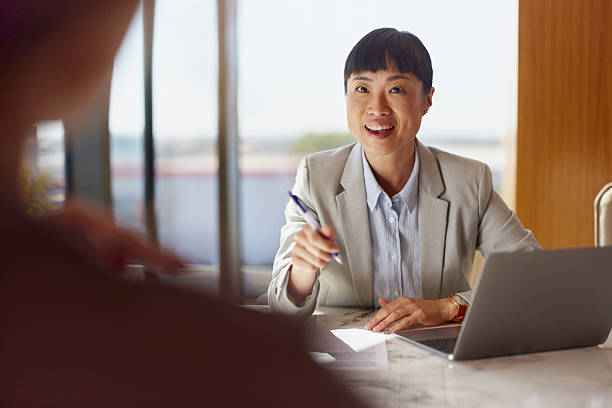 istock Happy Japanese advisor talking to her customer in the office. 2233135407