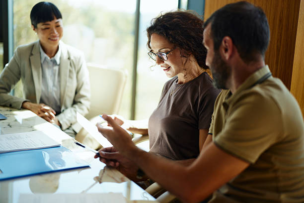 istock Happy couple reading contract on a meeting with their insurance agent. 2233135421