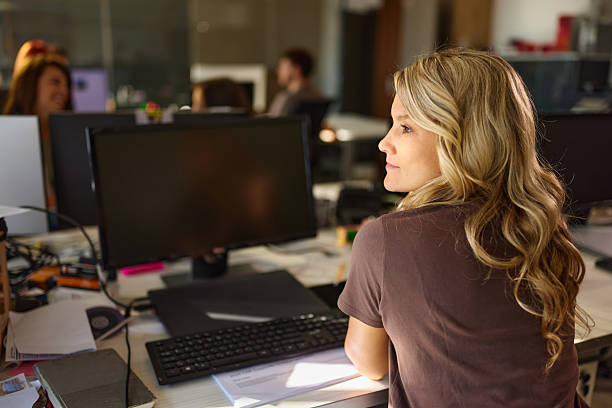 istock Smiling female designer working on PC in the office. 2233135519