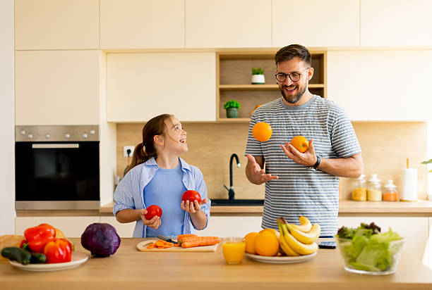 istock Father and daughter enjoy fun cooking time while juggling fresh produce 2233136882
