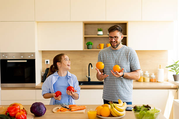 istock Father and daughter share a playful moment in a sunny kitchen 2233137392