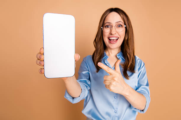 istock Excited professional pointing to a smartphone screen on beige background, showcasing advertising opportunities and modern lifestyle. 2233137653