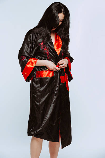 istock Young asian woman tying her black and red silk robe 2233138643