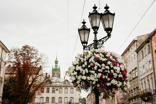 This vibrant street view draws attention from the close-up flowers and ironwork to the distinctive green dome and tower peaking above the surrounding structures.