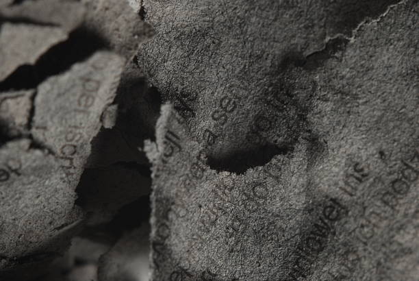istock A burnt sheet of papper with text on it, close-up 2233142756