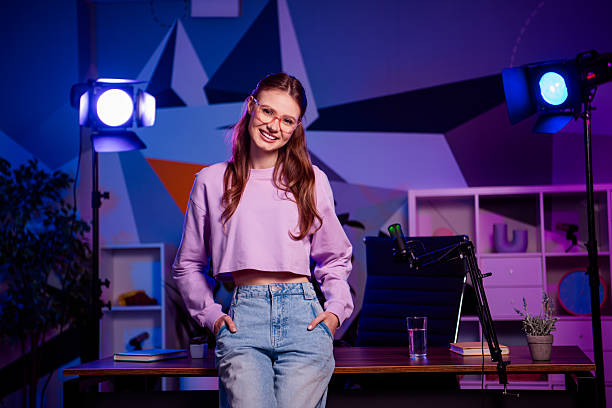 istock Young female podcaster in a decorated studio with neon lights, recording a professional streaming session at night 2233143253