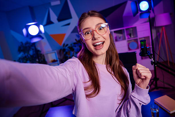istock Young blogger with captivating smile creating engaging content in neon-lit studio with vibrant atmosphere 2233143282