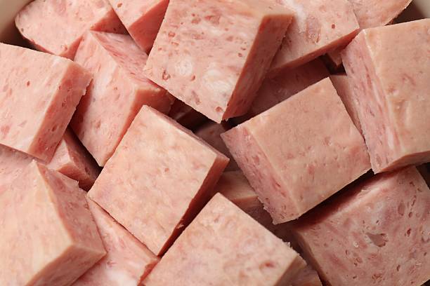 Pieces of canned meat as background, closeup