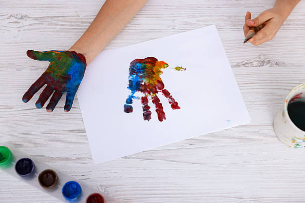 istock Boy drawing with palm at light wooden table, top view 2233151599
