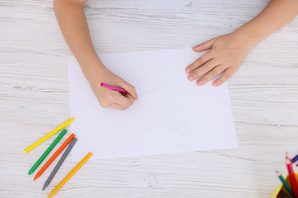 istock Boy drawing picture at light wooden table, top view 2233151676
