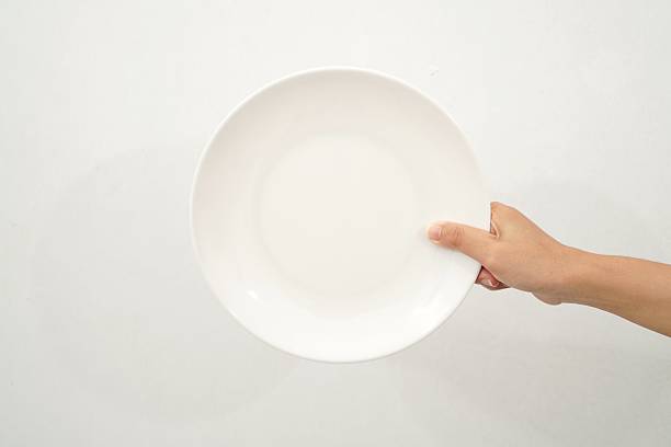istock Female holding clean ceramic plate isolated on white background, closeup 2233152040