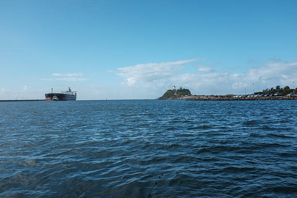 istock Coal ship being guided through a harbour by tugboats 2233152735