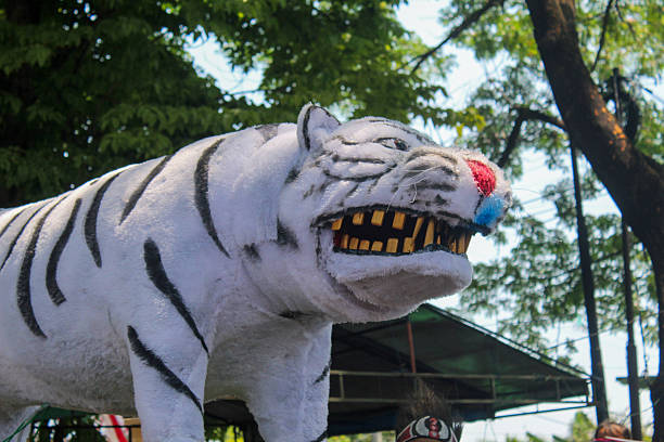 A white tiger statue is carried at a carnival event.