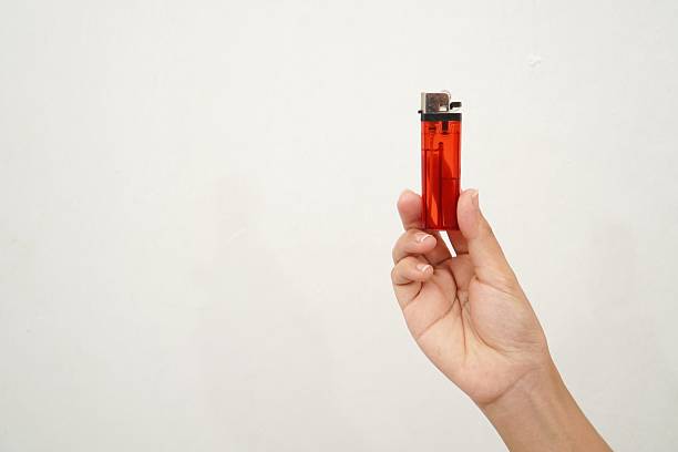 istock woman's hand holding a red gas lighter isolated on a white background 2233153330