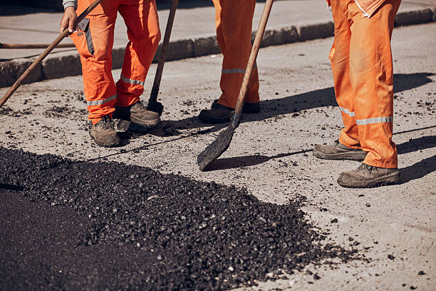 istock Construction workers working on a new asphalt layer on a public street. 2233153431