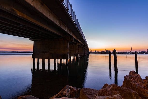 istock Forster Tuncurry Bridge spanning the lake at sunset, casting reflections on the water 2233153955