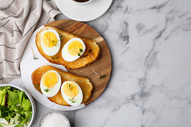 istock Sandwiches with hard boiled eggs on white marble table, flat lay. Space for text 2233162834