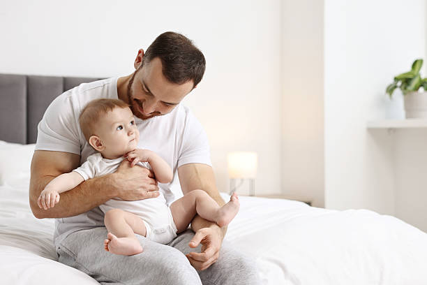 istock Father with his little baby on bed at home. Space for text 2233163604