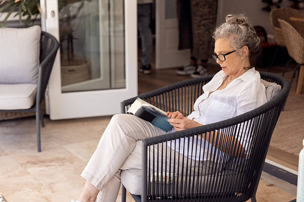 istock Senior Woman Reading Book at patio 2233164420