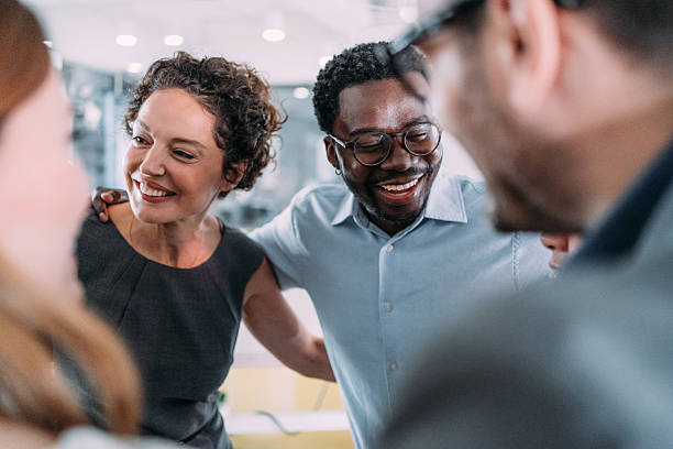 istock Excited coworkers embracing each other during a celebration in the office. 2233165254