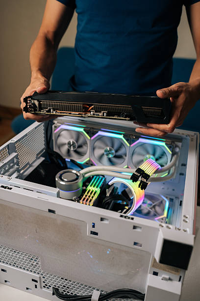istock Vertical cropped shot of computer technician installing powerful new graphic card into custom-built gaming pc, featuring vibrant RGB lighting and advanced water cooling system 2233166430