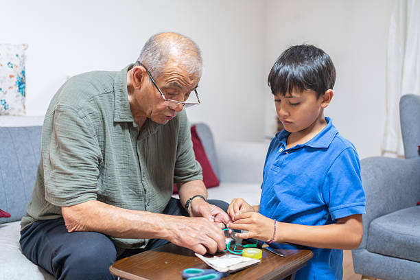 Grandchild  And Grandfather Working On School Project At Home