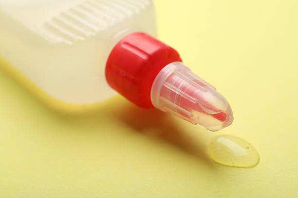 istock Bottle of glue on yellow background, closeup 2233173300