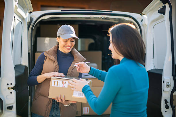 istock Young female delivery worker passing patcel to customer. 2233173325